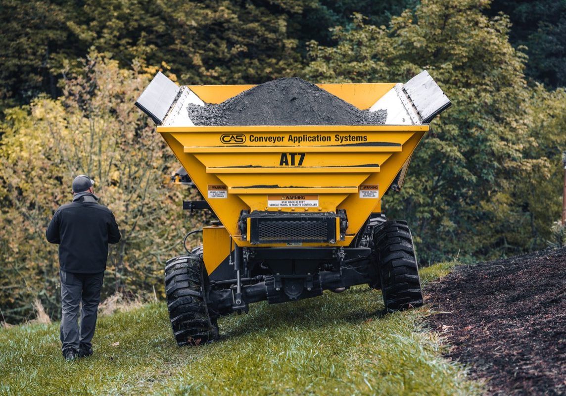 Operator walking beside a CAS AT7 off-road slinger